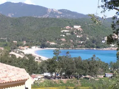 a view of a beach with trees and mountains at Villa Mimosa in Favone