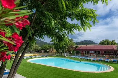 a large swimming pool with chairs and a resort at Camping Acqua E Sole in Sainte-Lucie de Porto-Vecchio