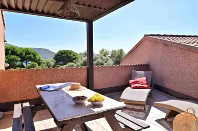 a table and chairs on a patio with a view at U Casinu in Piana