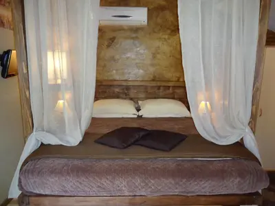 a bed with curtains and two pillows in a room at Villa Praesidio in Riventosa