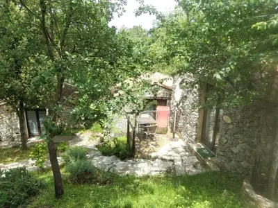 a stone house with a red chair in a yard at Villa Praesidio in Riventosa