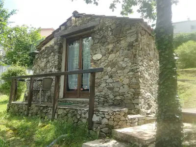 a small stone house with a window and a tree at Villa Praesidio in Riventosa
