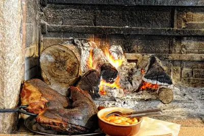 a fire in a brick oven with a bowl of food at Auberge U Licettu in Cuttoli-Corticchiato