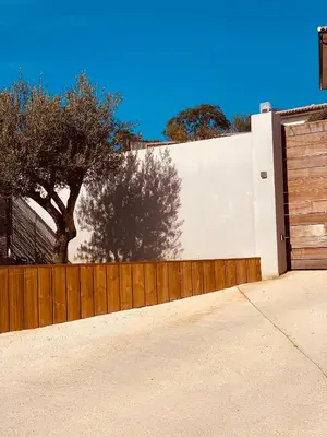 a fence with a wooden gate and a wooden door at Senteurs du Maquis in Porticcio