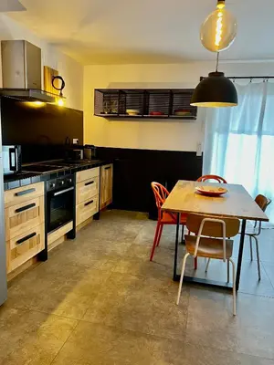 a kitchen with a wooden table and a dining room at Senteurs du Maquis in Porticcio