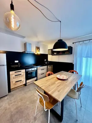 a kitchen with a wooden table and chairs at Senteurs du Maquis in Porticcio