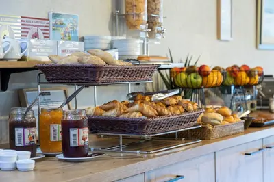 a buffet with baskets of bread and other foods at Hôtel La Pinède in Ajaccio