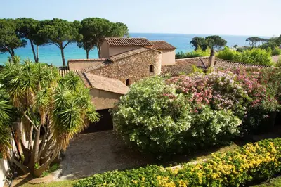 a building with a bunch of plants and flowers at Hôtel La Pinède in Ajaccio