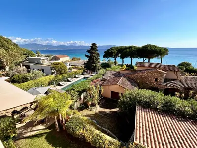 an aerial view of a house with the ocean in the background at Hôtel La Pinède in Ajaccio