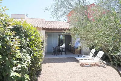 a patio with chairs and a table in a yard at Résidence Tamaris 2 in Porto-Vecchio