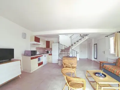 a kitchen and living room with a couch and chairs at Résidence Tamaris 2 in Porto-Vecchio