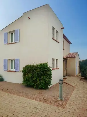 a white house with blue shuttered windows on it at Résidence Tamaris 2 in Porto-Vecchio