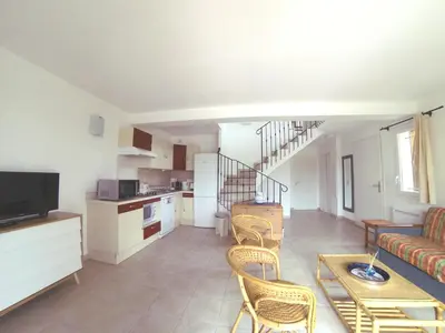 a living room with a couch and a table and chairs at Résidence Tamaris 2 in Porto-Vecchio