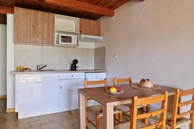 a kitchen with a wooden table with a bowl of fruit on it at Motel de Porticcio in Porticcio