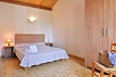 a bedroom with a bed and a chair at Motel de Porticcio in Porticcio