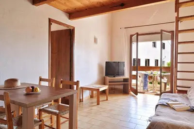 a living room with a table and a tv at Motel de Porticcio in Porticcio