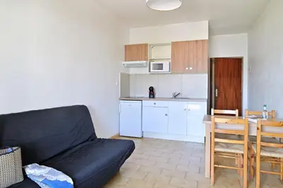 a living room with a couch and a kitchen at Motel de Porticcio in Porticcio