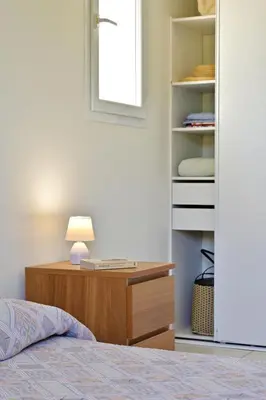 a bedroom with a bed and a desk with a lamp at Isula Bianca in Porticcio