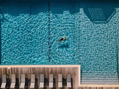 a person swimming in a swimming pool with a swimmer in the water at Hotel Costa Salina in Porto-Vecchio