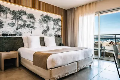 a bedroom with a large bed and a large window at Hotel Costa Salina in Porto-Vecchio