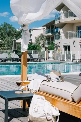 a bed and a table next to a pool at Hotel Costa Salina in Porto-Vecchio