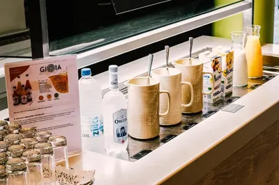 a counter with several bottles and mugs on it at Hotel Costa Salina in Porto-Vecchio