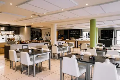 a dining room with tables and white chairs at Hotel Costa Salina in Porto-Vecchio
