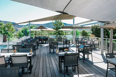 an outdoor restaurant with tables and chairs and umbrellas at Hotel Costa Salina in Porto-Vecchio
