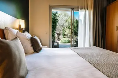 a bedroom with a large bed and a window at Hotel Costa Salina in Porto-Vecchio