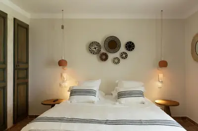 a bedroom with a large white bed with two tables at Casa Santini x Roc Seven in Porto-Vecchio