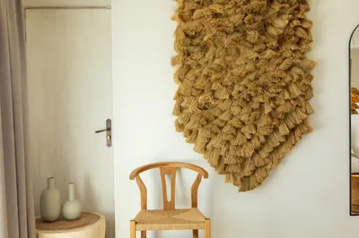 a wreath hanging on a wall next to a chair at Casa Santini x Roc Seven in Porto-Vecchio
