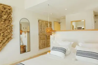 a bedroom with a bed with two pillows and a mirror at Casa Santini x Roc Seven in Porto-Vecchio