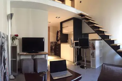 a living room with a staircase and a laptop computer at U Palazzinu in Porto-Vecchio