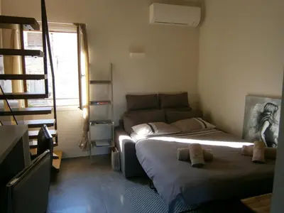 a small bedroom with a bed and a window at U Palazzinu in Porto-Vecchio