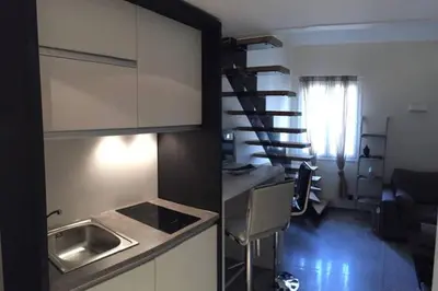 a kitchen and a living room with a spiral stair at U Palazzinu in Porto-Vecchio