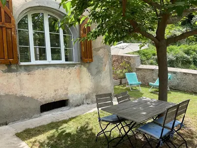 a picnic table and chairs sitting under a tree at Casa Defranchi in Sant Andrea di Bozio