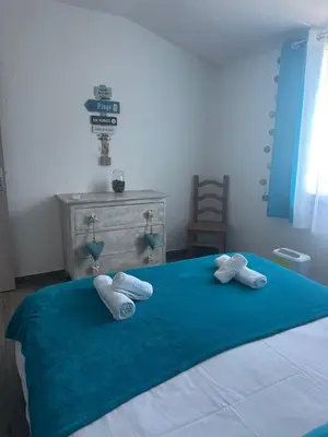 a bedroom with a blue bed with towels on it at A Santa Trinita in Bonifacio