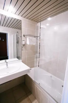 a bathroom with a tub and a sink and a shower at Hôtel Cala di Sole in Ajaccio