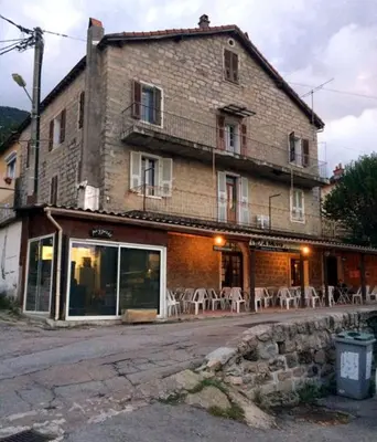 a building with tables and chairs in front of it at 95m2 au calme à 25mn AJACCIO, plages, linge inclus parking ok in Ucciani