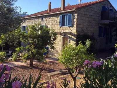 a stone house with a garden in front of it at Le moulin de Figari, nouvelle climatisation in Figari