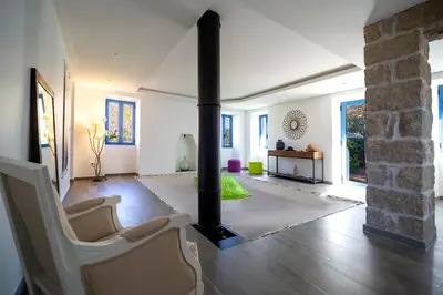 a living room with a fireplace and a couch and chairs at Le moulin de Figari, nouvelle climatisation in Figari