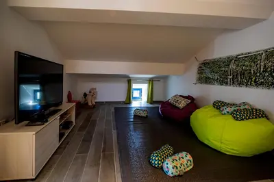 a living room with a green bean bag chair and a flat screen tv at Le moulin de Figari, nouvelle climatisation in Figari