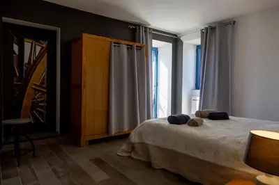a bedroom with a bed and a large window at Le moulin de Figari, nouvelle climatisation in Figari