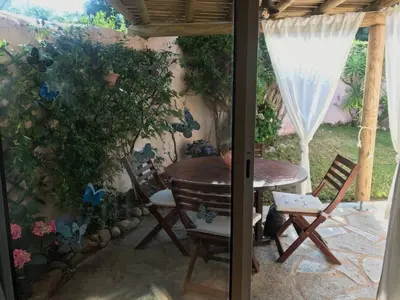 a patio with a table and chairs on a patio at Minivilla Marina di Santa Giulia in Porto-Vecchio