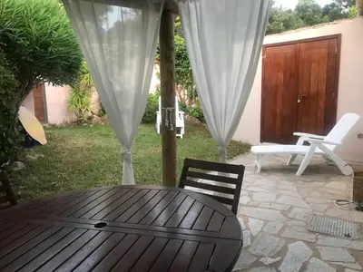 a wooden table and chairs on a patio at Minivilla Marina di Santa Giulia in Porto-Vecchio