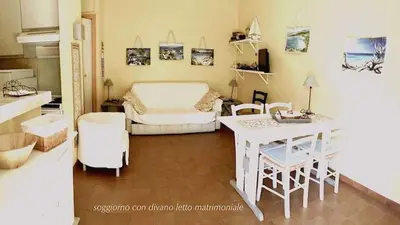 a bedroom with a bed and a desk and a table at Minivilla Marina di Santa Giulia in Porto-Vecchio