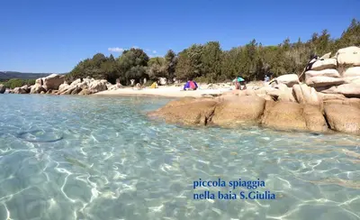a beach with a group of people on the shore at Minivilla Marina di Santa Giulia in Porto-Vecchio
