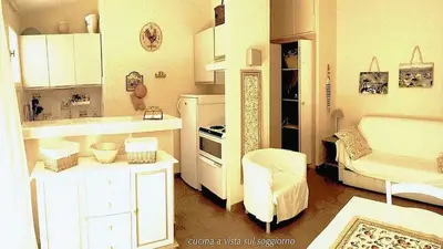a small kitchen with a couch and a chair at Minivilla Marina di Santa Giulia in Porto-Vecchio