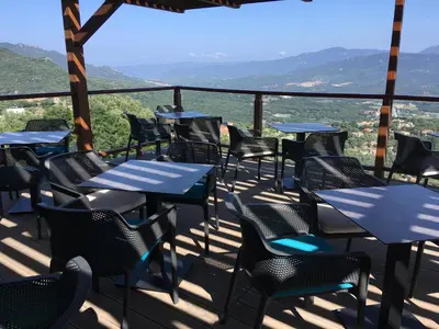 a group of tables and chairs on a balcony at Best Western Plus San Damianu in Sartène