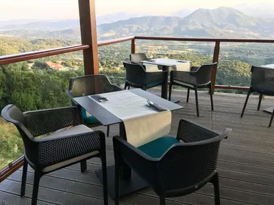 a restaurant with tables and chairs on a deck at Best Western Plus San Damianu in Sartène